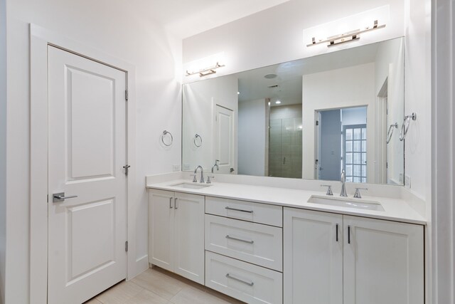 full bathroom featuring a sink, a stall shower, and double vanity