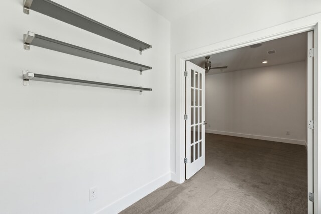 hallway featuring visible vents, baseboards, and carpet flooring