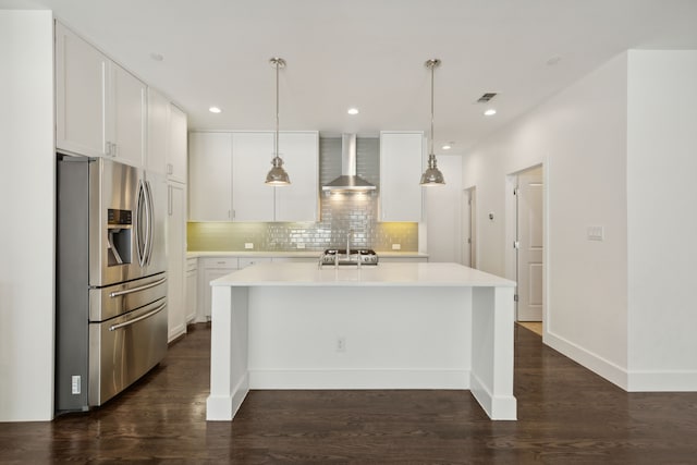 kitchen featuring white cabinets, stainless steel fridge, dark hardwood / wood-style flooring, and wall chimney range hood