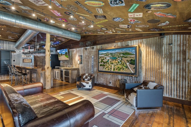 living room featuring bar area, lofted ceiling, wood walls, and hardwood / wood-style flooring