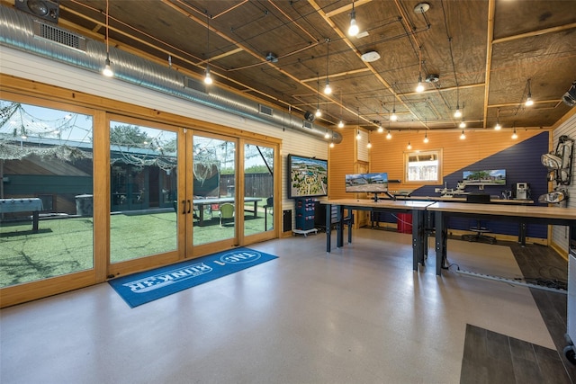 recreation room with concrete flooring and rail lighting