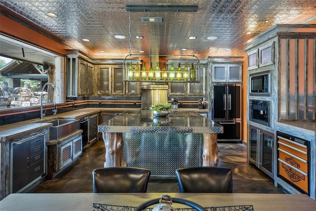 kitchen featuring dark stone counters, a center island, black appliances, dark brown cabinetry, and sink