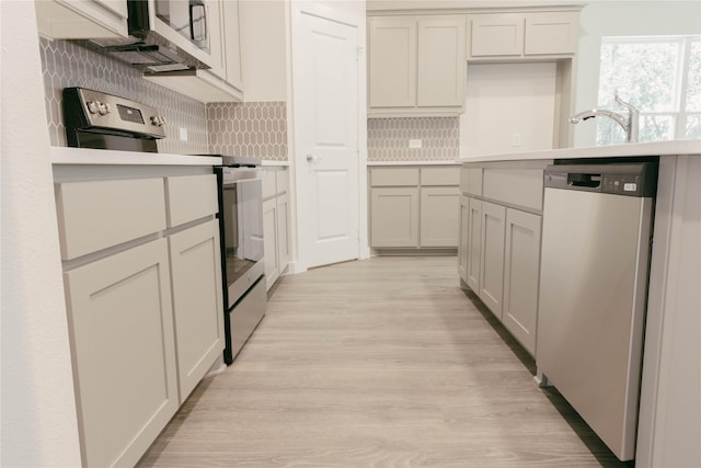 kitchen featuring light hardwood / wood-style floors, white cabinets, appliances with stainless steel finishes, and decorative backsplash