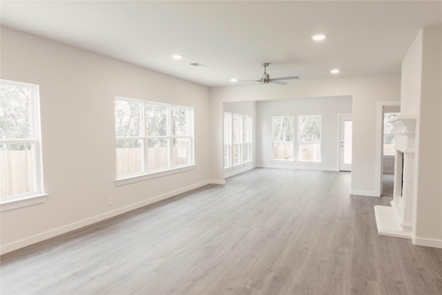 unfurnished living room featuring ceiling fan and light wood-type flooring