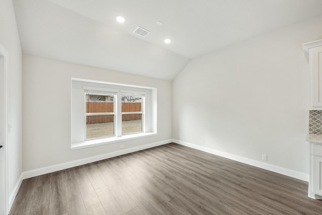 carpeted bedroom featuring multiple windows, ensuite bathroom, and lofted ceiling