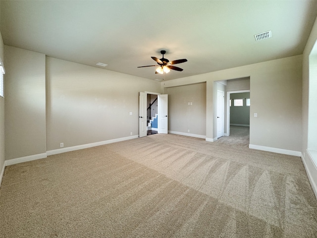 carpeted spare room with ceiling fan