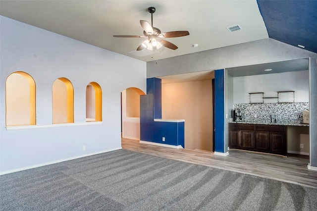 unfurnished living room with light wood-type flooring, sink, and ceiling fan