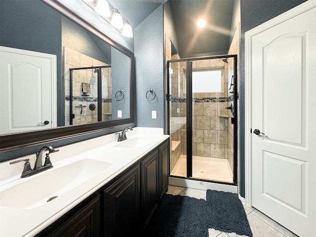 bathroom with a shower with door, vanity, and tile patterned floors