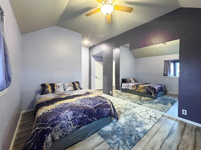 bedroom with ceiling fan, hardwood / wood-style flooring, and vaulted ceiling