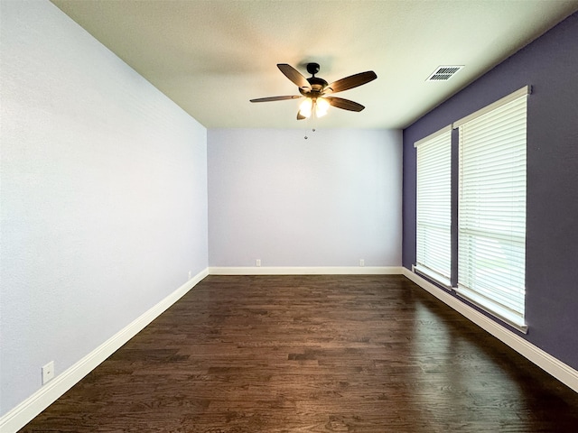 unfurnished room featuring dark wood-type flooring and ceiling fan