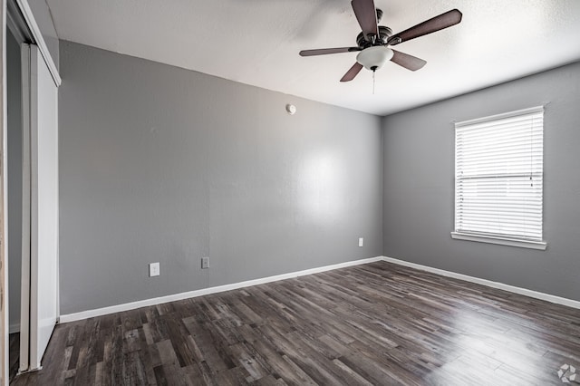 unfurnished room with dark wood-type flooring and ceiling fan