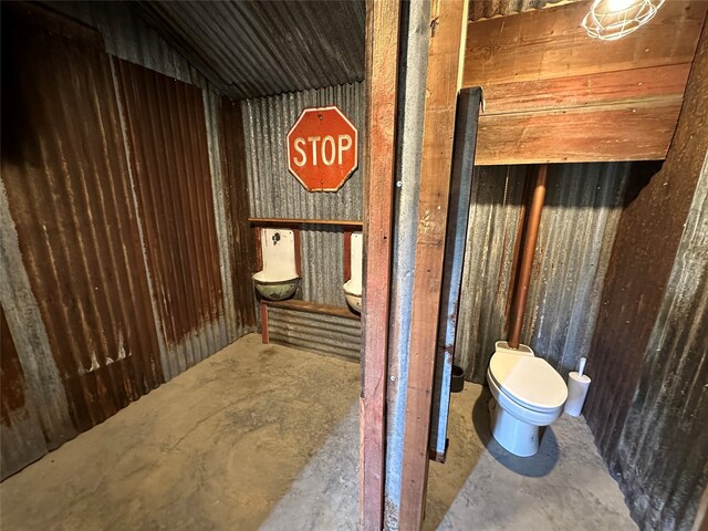 bathroom featuring concrete flooring and toilet