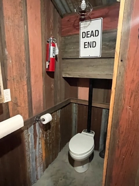 bathroom featuring concrete floors and toilet