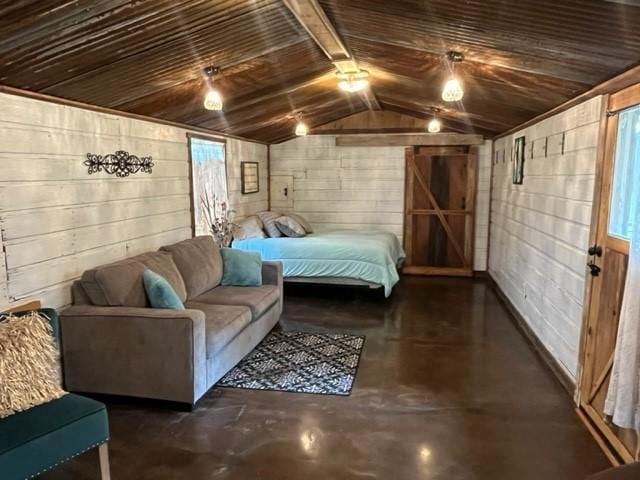 bedroom featuring concrete block wall, wood ceiling, concrete floors, and lofted ceiling