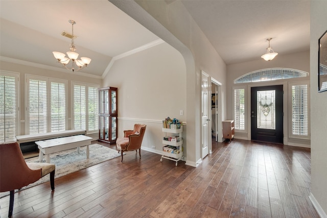 foyer featuring crown molding, dark hardwood / wood-style flooring, a chandelier, and lofted ceiling