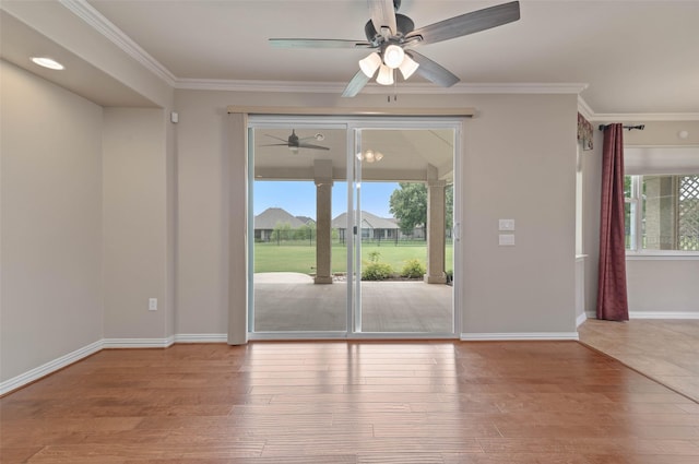 empty room featuring crown molding, a healthy amount of sunlight, and light hardwood / wood-style floors