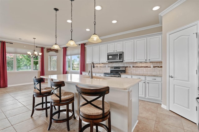 kitchen with an island with sink, appliances with stainless steel finishes, sink, and white cabinets