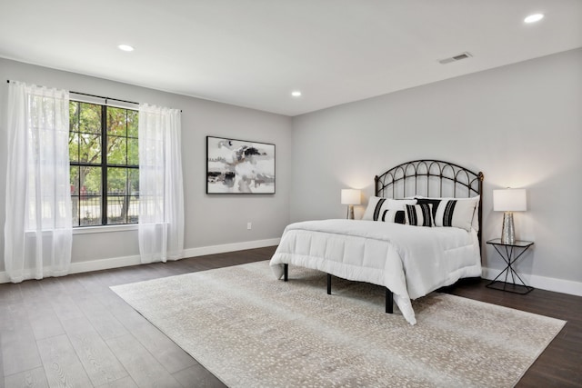 bedroom with recessed lighting, visible vents, baseboards, and wood finished floors