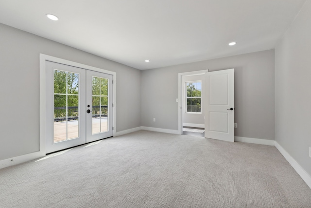 carpeted spare room featuring french doors, recessed lighting, a wealth of natural light, and baseboards