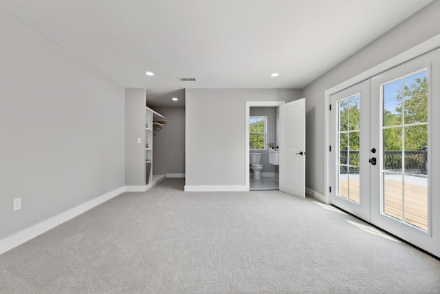 unfurnished room featuring baseboards, french doors, visible vents, and light colored carpet