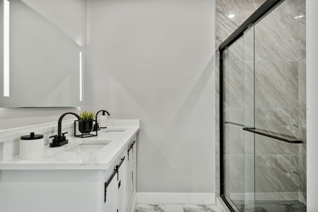 bathroom with marble finish floor, a sink, a shower stall, and baseboards