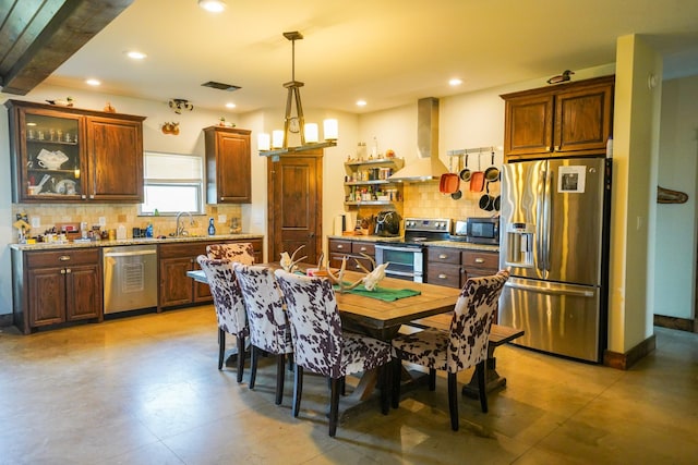 kitchen featuring sink, stainless steel appliances, tasteful backsplash, extractor fan, and decorative light fixtures