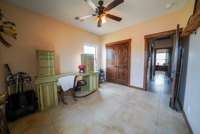 interior space featuring light tile patterned flooring and ceiling fan