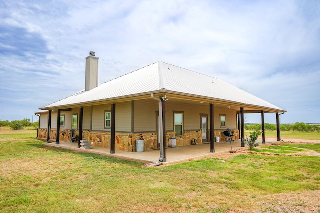 rear view of house with a lawn and a patio