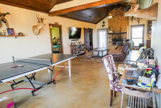 rec room with a fireplace, lofted ceiling with beams, light tile patterned floors, ceiling fan, and wooden ceiling