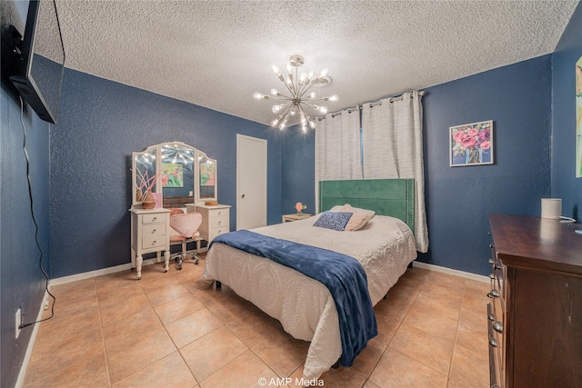 bedroom with light tile patterned flooring, a textured ceiling, a notable chandelier, and a textured wall