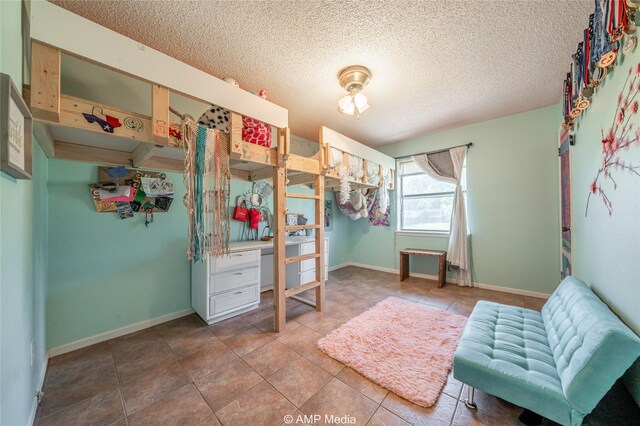 tiled bedroom with a textured ceiling and baseboards