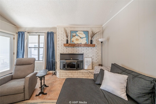 living area with a brick fireplace, a textured ceiling, tile patterned floors, vaulted ceiling, and ornamental molding