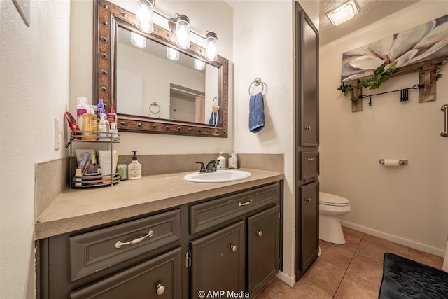 bathroom featuring tile patterned flooring, baseboards, toilet, and vanity