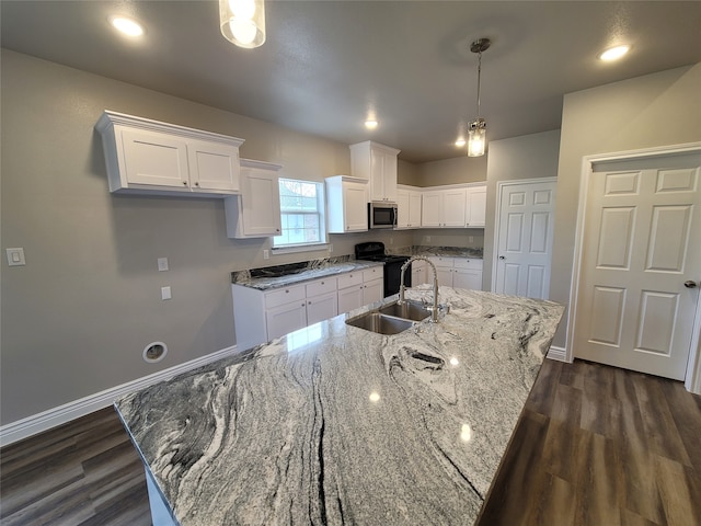 kitchen featuring white cabinets, black electric range, sink, and an island with sink