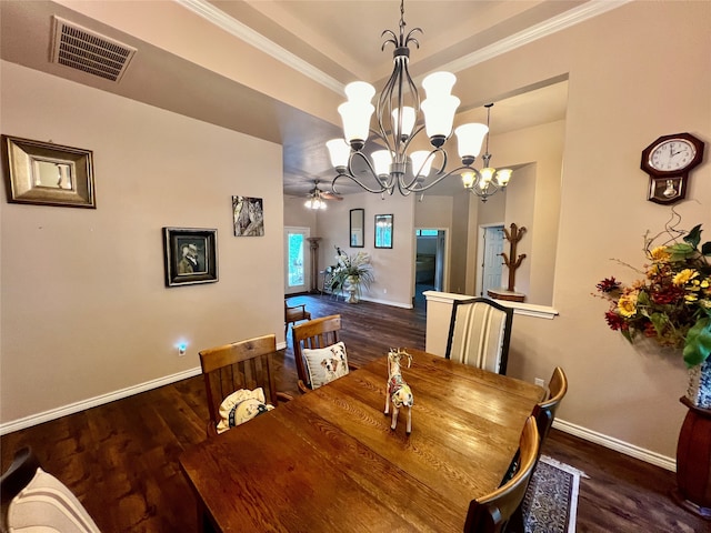 dining space featuring dark wood-type flooring, ornamental molding, and ceiling fan with notable chandelier