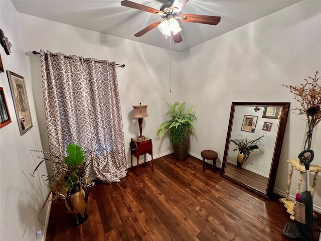 living area with ceiling fan and dark hardwood / wood-style flooring