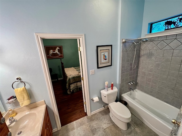 full bathroom with toilet, tiled shower / bath, hardwood / wood-style flooring, and vanity