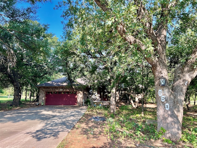 view of property hidden behind natural elements featuring a garage