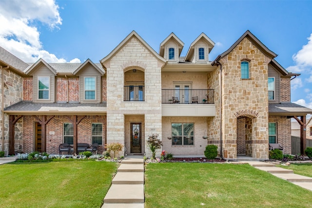 view of front of home featuring a balcony and a front yard