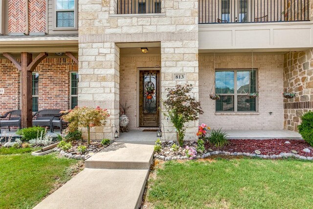 property entrance featuring a balcony and a yard