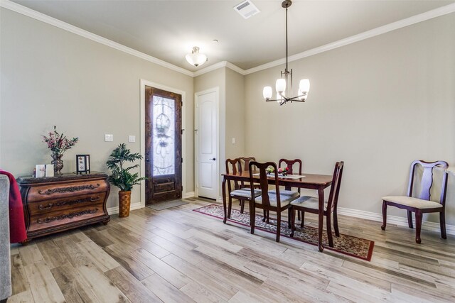 dining room featuring wood-type flooring, crown molding, and an inviting chandelier