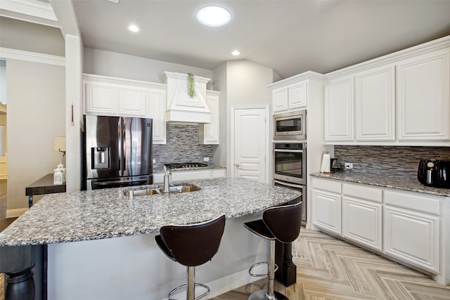 kitchen with white cabinetry, premium range hood, tasteful backsplash, stainless steel appliances, and light parquet flooring