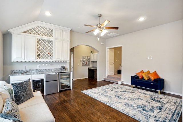 living room featuring beverage cooler, ceiling fan, dark hardwood / wood-style floors, vaulted ceiling, and sink