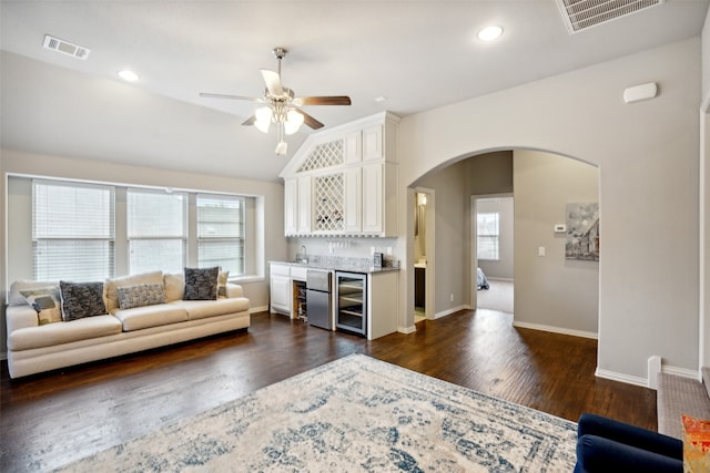 living room with beverage cooler, ceiling fan, dark hardwood / wood-style floors, vaulted ceiling, and sink