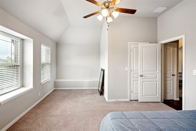 unfurnished bedroom featuring a closet, carpet, ceiling fan, and vaulted ceiling