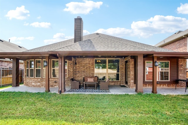 back of house with a patio and a lawn