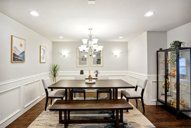 dining space featuring dark hardwood / wood-style flooring and a chandelier