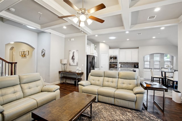 living room with dark wood-type flooring, ceiling fan, beam ceiling, and coffered ceiling