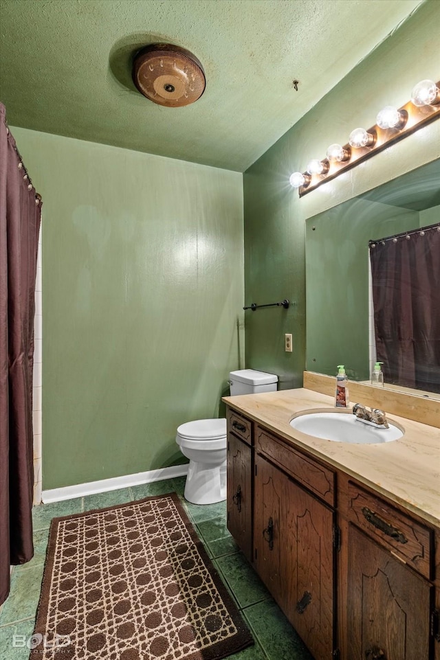 bathroom with toilet, a textured ceiling, and vanity