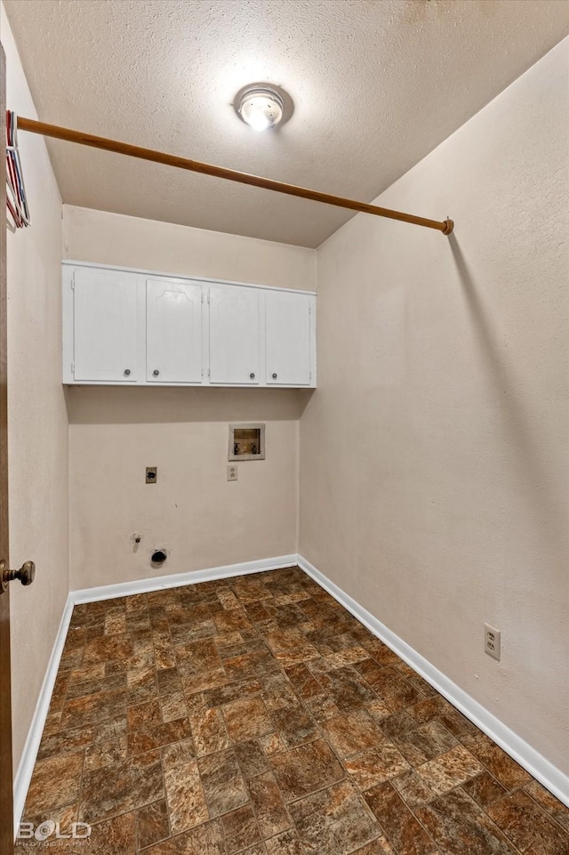 clothes washing area with hookup for an electric dryer, hookup for a gas dryer, cabinets, a textured ceiling, and washer hookup